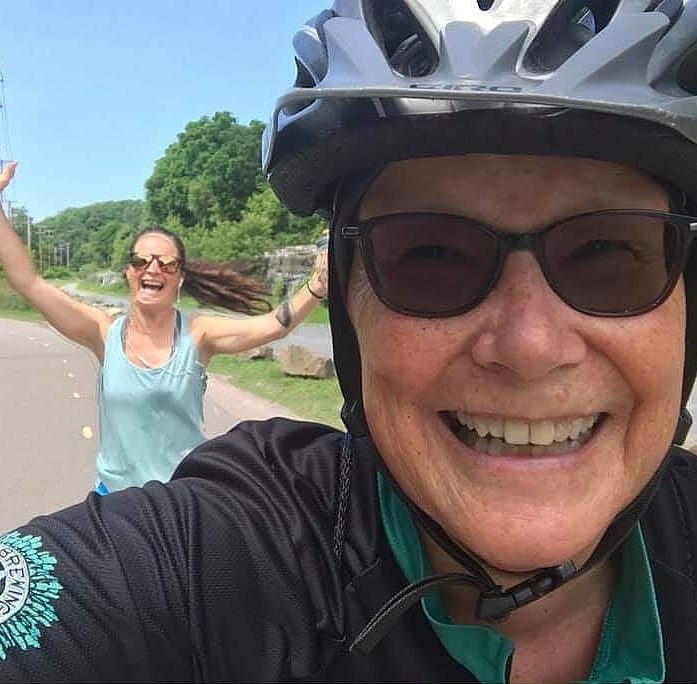 Emily's mom riding the bike while she runs