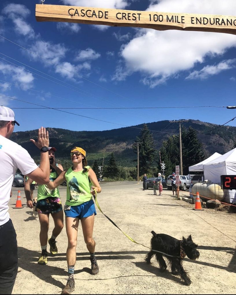 The author goes in for a high five during the 2019 Cascade Crest; she’s run a handful of 100-milers since her first 100-mile race in 2014. (Photo Courtesy: Emily Halnon)