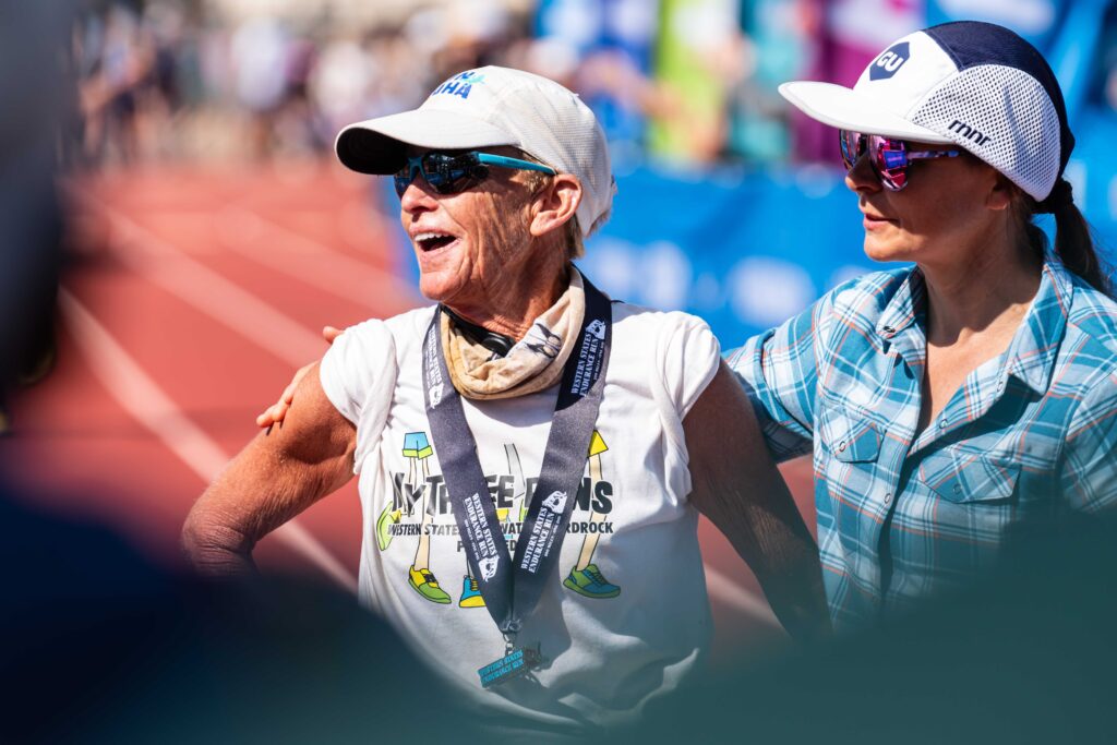 The oldest female finisher, Pam Reed, soaks in the finish line atmosphere
