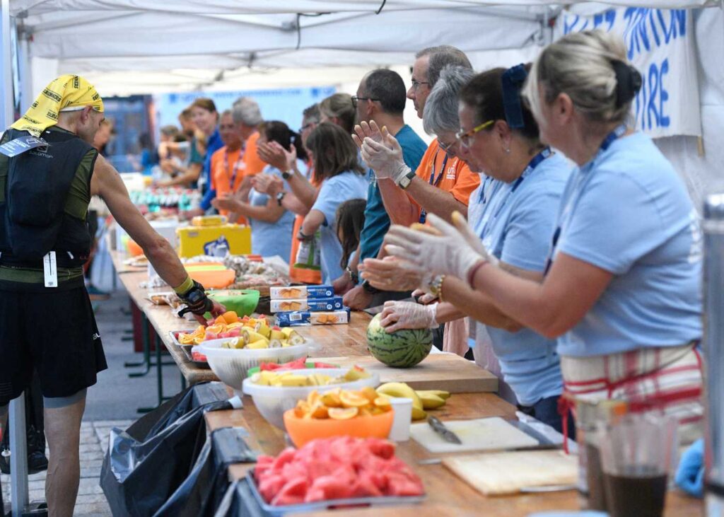 Runners come into a well-stocked aid station on the course at UTMB