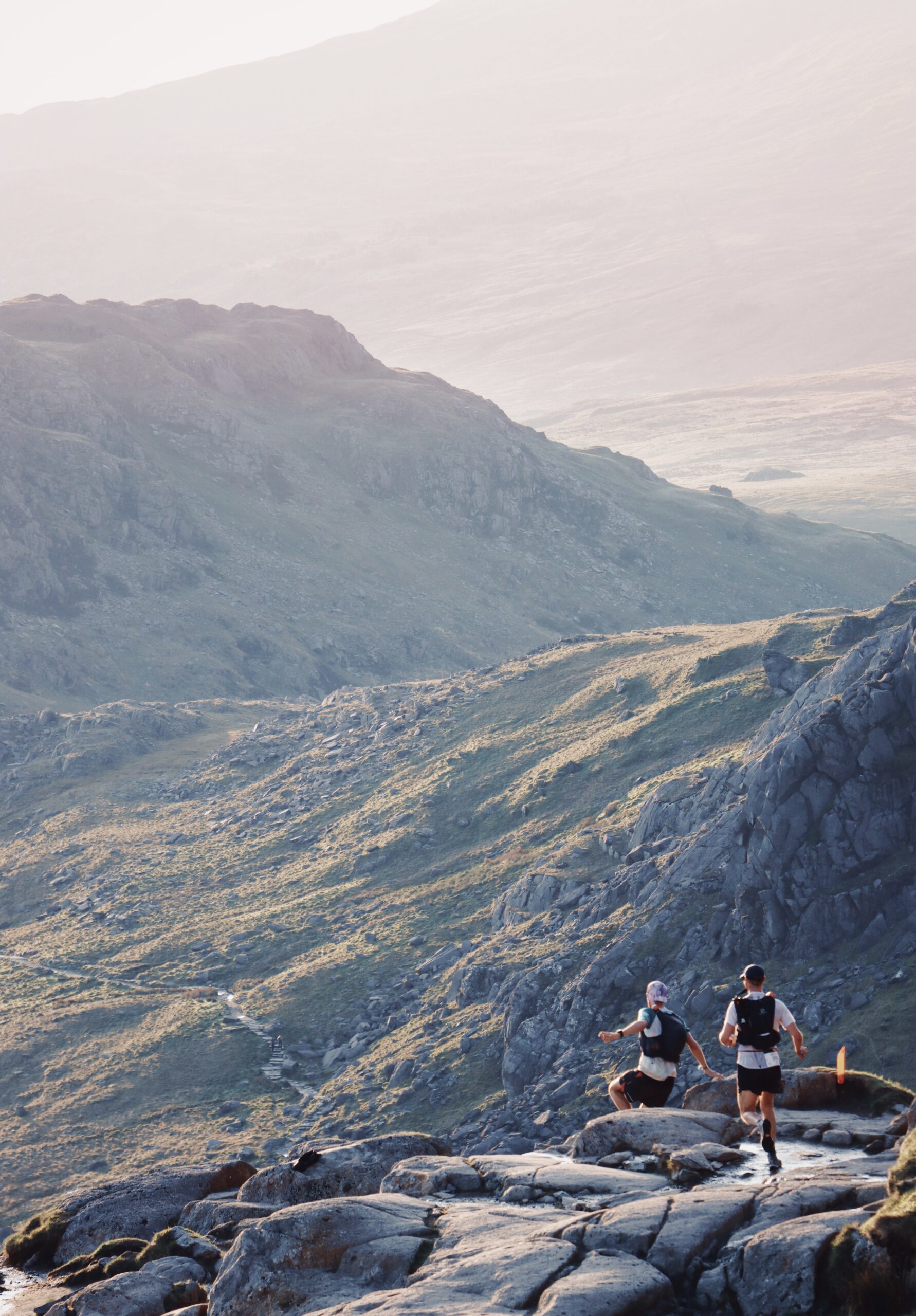 Ultra runners Tom Owens & Hugh Chatfield descending the Pyg Track during first light at Ultra Trail Snowdonia, UK.